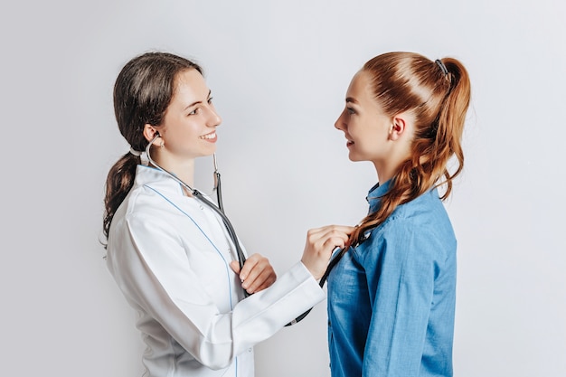 Medico che controlla la salute del paziente della donna con lo stetoscopio sullo spazio isolato bianco