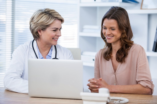 Medico che discute con il paziente sul computer portatile