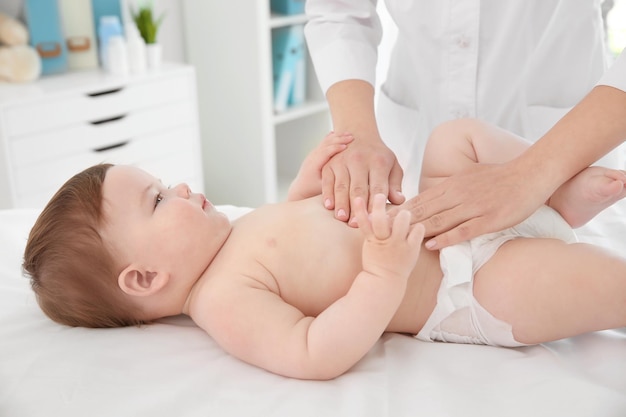 Medico che esamina il piccolo bambino in clinica Concetto di salute del bambino