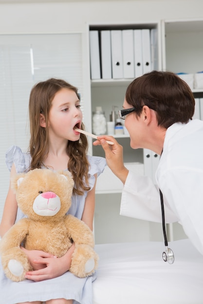 Medico che esamina la bocca della bambina