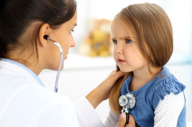 Medico che esamina una bambina con lo stetoscopio.