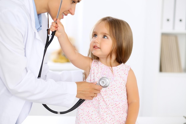 Medico che esamina una bambina dallo stetoscopio