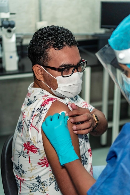 Medico che inietta a un uomo il vaccino covid 19.