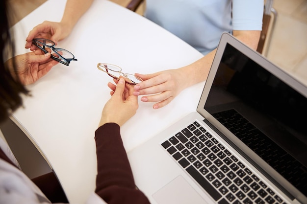 Medico che introduce due paia di occhiali a una persona