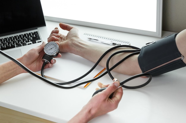 Medico che misura la pressione sanguigna in una clinica Concetto di industria sanitaria
