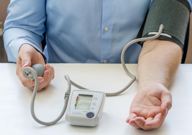 Medico che misura la sua pressione sanguigna