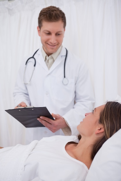 Medico che parla con il paziente costretto a letto