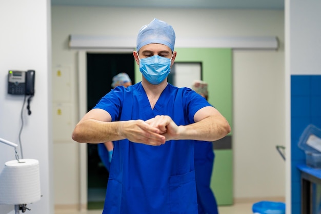 Medico che si prepara per l'intervento chirurgico Il chirurgo indossa indumenti sterili prima dell'intervento chirurgico