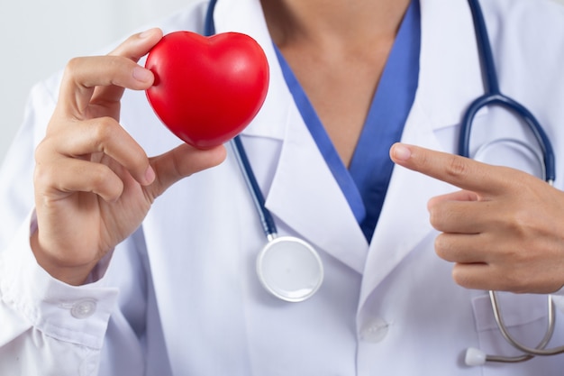 Medico che tiene il concetto di cuore e il trattamento delle malattie cardiache