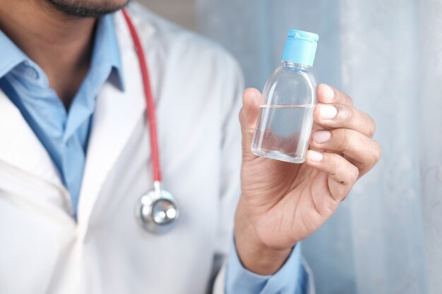 Medico che tiene il disinfettante per le mani da vicino