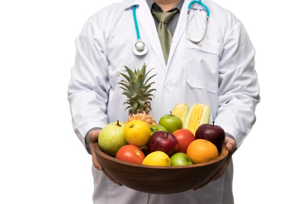 Medico che tiene la frutta fresca e le verdure dell'assort del canestro isolati