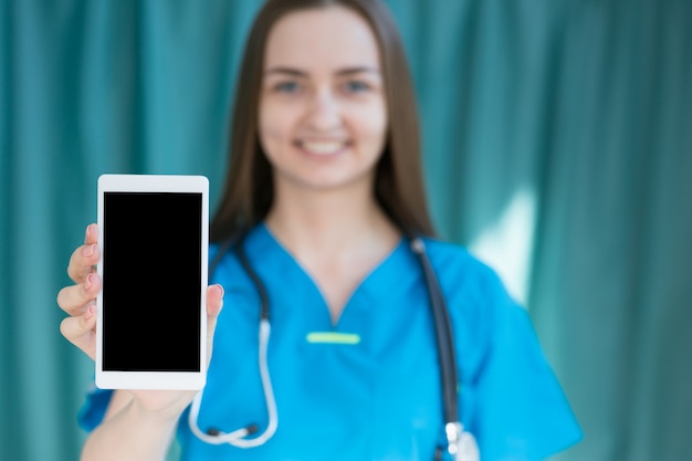 Medico che tiene smartphone in mano, foto con profondità di campo