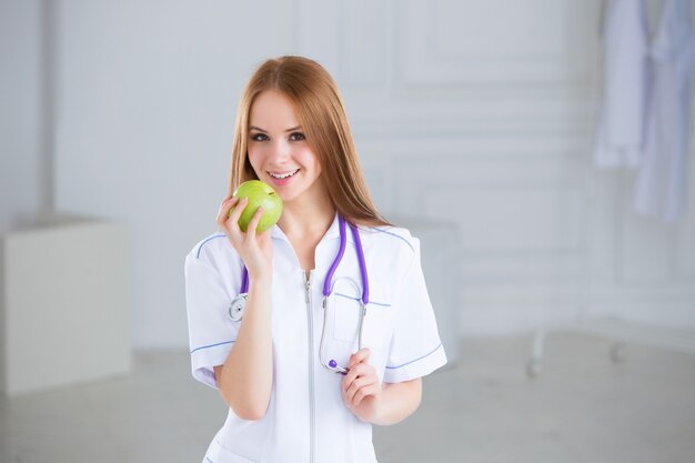 Medico che tiene una mela verde. Concetto di cibo sano.