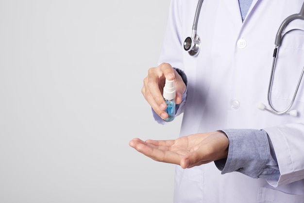 Medico che utilizza spray spray per la pulizia delle mani per proteggere l'antivirus