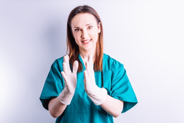 Medico chirurgo con stetoscopio sorridente guardando dritto davanti ad applaudire il concetto di congratulazioni mediche per buoni risultati