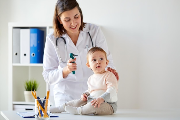 medico con il bambino e l'otoscopio in clinica