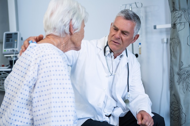 Medico consolante paziente anziano