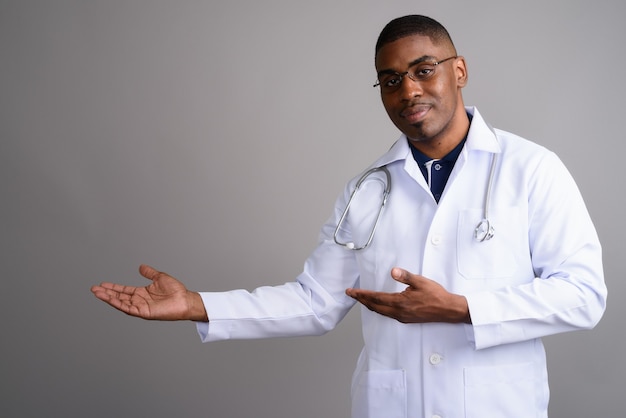 Medico del giovane uomo africano bello su gray