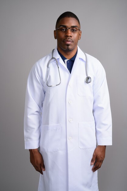 Medico del giovane uomo africano bello su gray