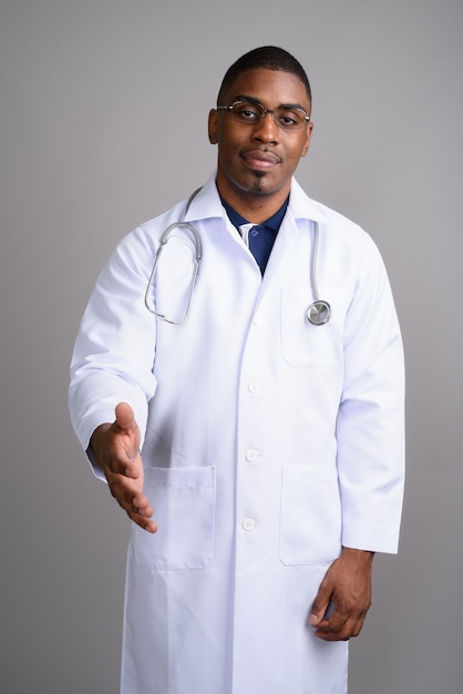 Medico del giovane uomo africano bello su gray