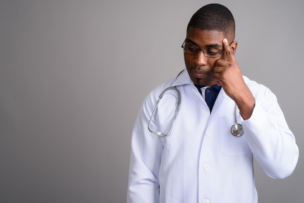 Medico del giovane uomo africano bello su gray