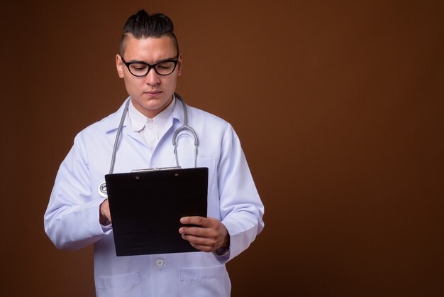 Medico dell'uomo multietnico bello del giovane su colore marrone