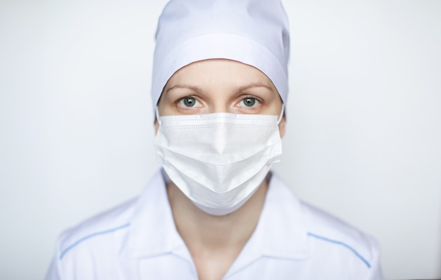 Medico della donna che indossa la maschera del protectiv su fondo bianco.