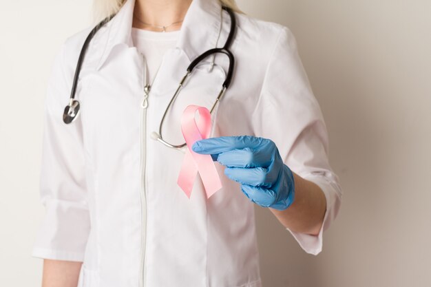 Medico della donna che tiene un nastro rosa nelle sue mani