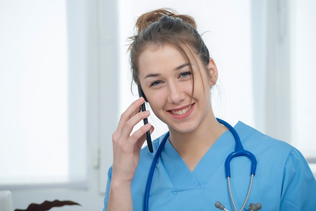 Medico della giovane donna che parla sul telefono