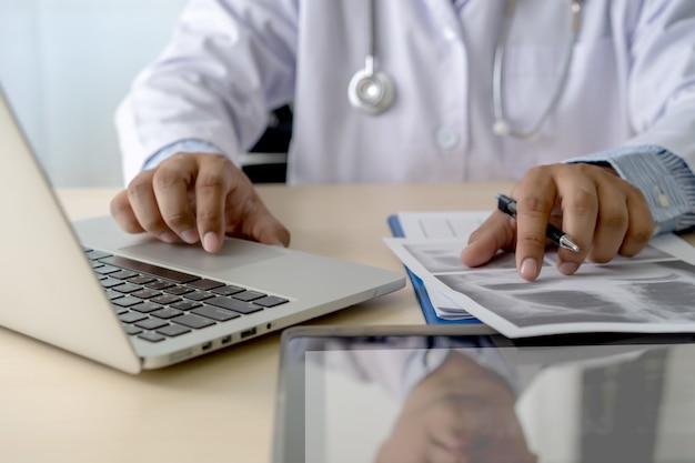 Medico di prescrizione di scrittura di assistenza sanitaria che lavora con il computer portatile