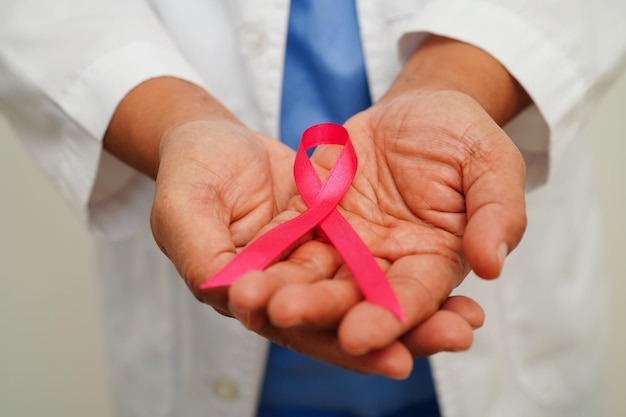 Medico donna asiatica con nastro rosa Giornata mondiale del cancro al seno a ottobre