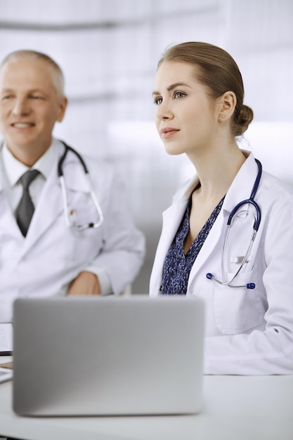 Medico donna che partecipa alla conferenza medica o all'incontro con i suoi colleghi maschi. Concetto di medicina.