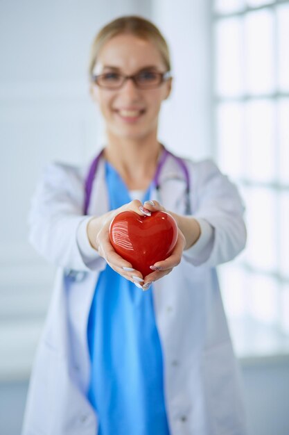 Medico donna con stetoscopio che tiene il cuore tra le braccia Concetto di assistenza sanitaria e cardiologia in medicina