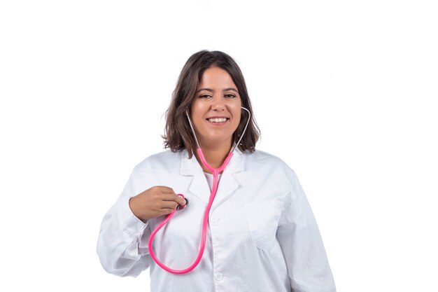 medico donna con stetoscopio rosa su sfondo bianco.