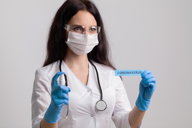 Medico donna in uniforme con in mano un'insegna di carta con scritta coronavirus