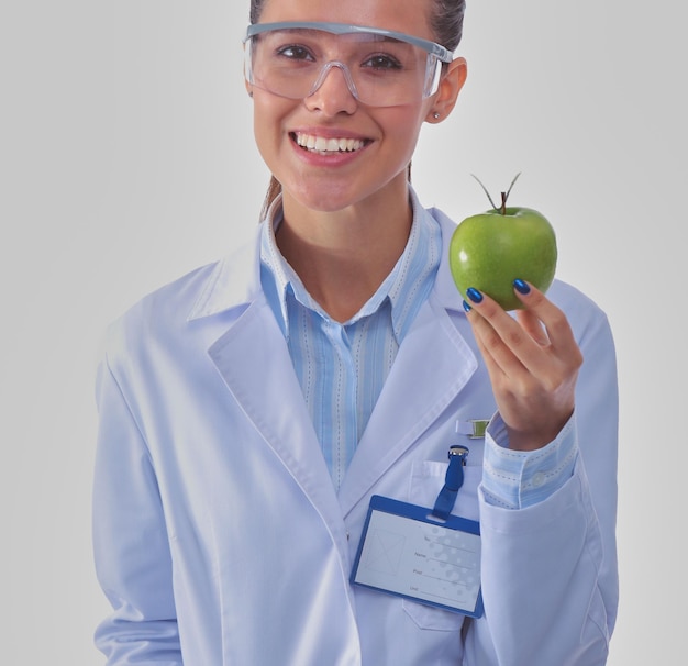Medico donna sorridente con una mela verde Medico donna