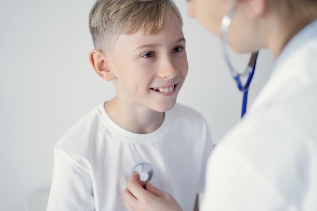 Medico e felice bambino sorridente paziente al solito controllo medico in clinica. Medicina, concetti sanitari