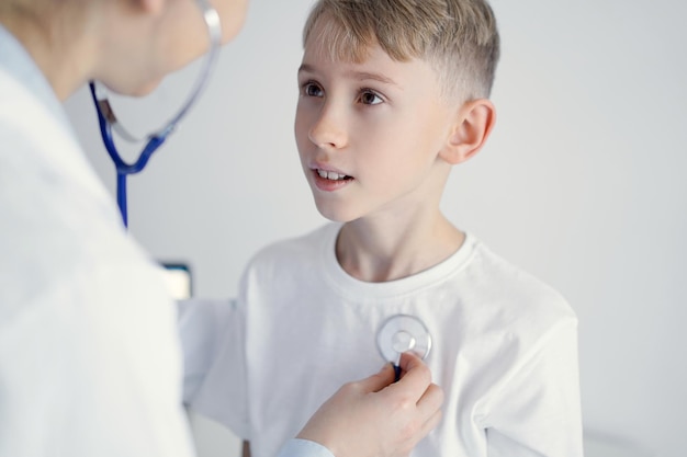 Medico e felice bambino sorridente paziente al solito controllo medico in clinica. Medicina, concetti sanitari