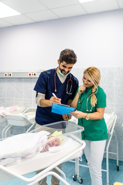 Medico e infermiere che esaminano il neonato in ospedale.