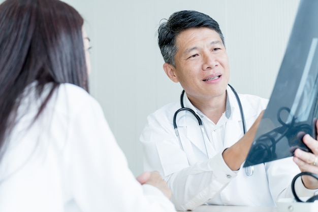 Medico e paziente asiatici stanno discutendo