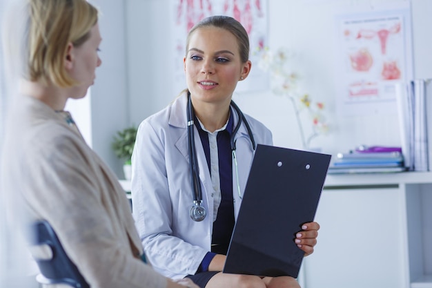 Medico e paziente che discutono di qualcosa seduti al tavolo Concetto di medicina e assistenza sanitaria