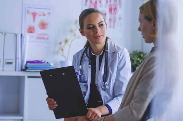 Medico e paziente che discutono di qualcosa seduti al tavolo concetto di medicina e assistenza sanitaria