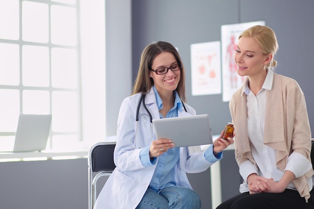 Medico e paziente che discutono di qualcosa seduti al tavolo Concetto di medicina e assistenza sanitaria