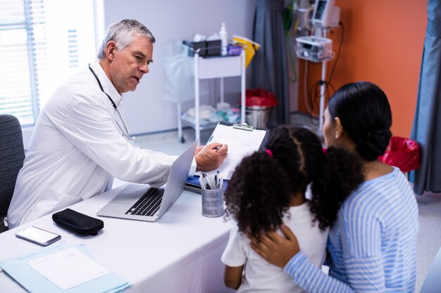 Medico e paziente che discutono sopra la lavagna per appunti