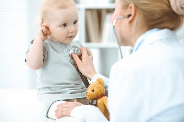 Medico e paziente in ospedale. La bambina viene esaminata dal medico con lo stetoscopio. Concetto di medicina.