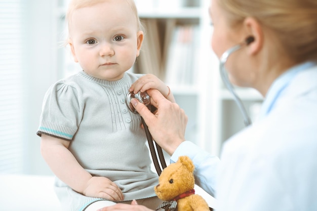 Medico e paziente in ospedale. La bambina viene esaminata dal medico con lo stetoscopio. Concetto di medicina.