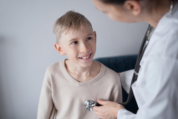 Medico e paziente sorridente felice del ragazzo del bambino a casa ispezione medica. Medicina, concetti sanitari