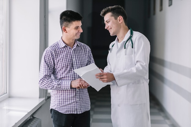 Medico e paziente sorridenti in sala