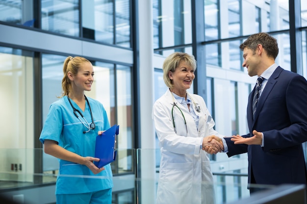 Medico femminile che agitano le mani con l'uomo d'affari