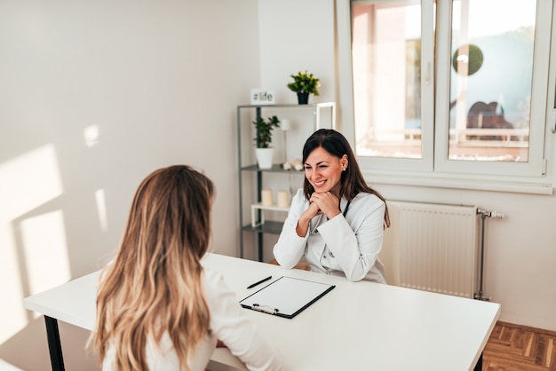 Medico femminile che ascolta il suo paziente che parla della sua malattia in ufficio medico